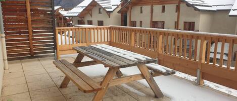 A wooden deck with a picnic table and a wooden fence.