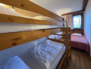 A bunk bed room with a window, a desk, and a small table. - BEL APPARTEMENT 4 PIECES POUR 10 PERSONNES (LES ORRES 1650)