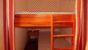 Une petite pièce étroite avec un lit superposé et une échelle.