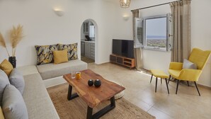 Een moderne woonkamer met een bank, salontafel, televisie en uitzicht op de stad door een raam.