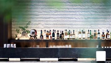 Um bar com uma variedade de garrafas de bebidas e copos à mostra.
