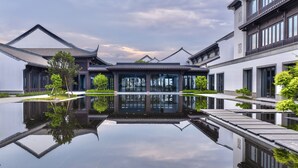A traditional building with a reflective water feature in front. - Grand Dongshan (Shaoxing)