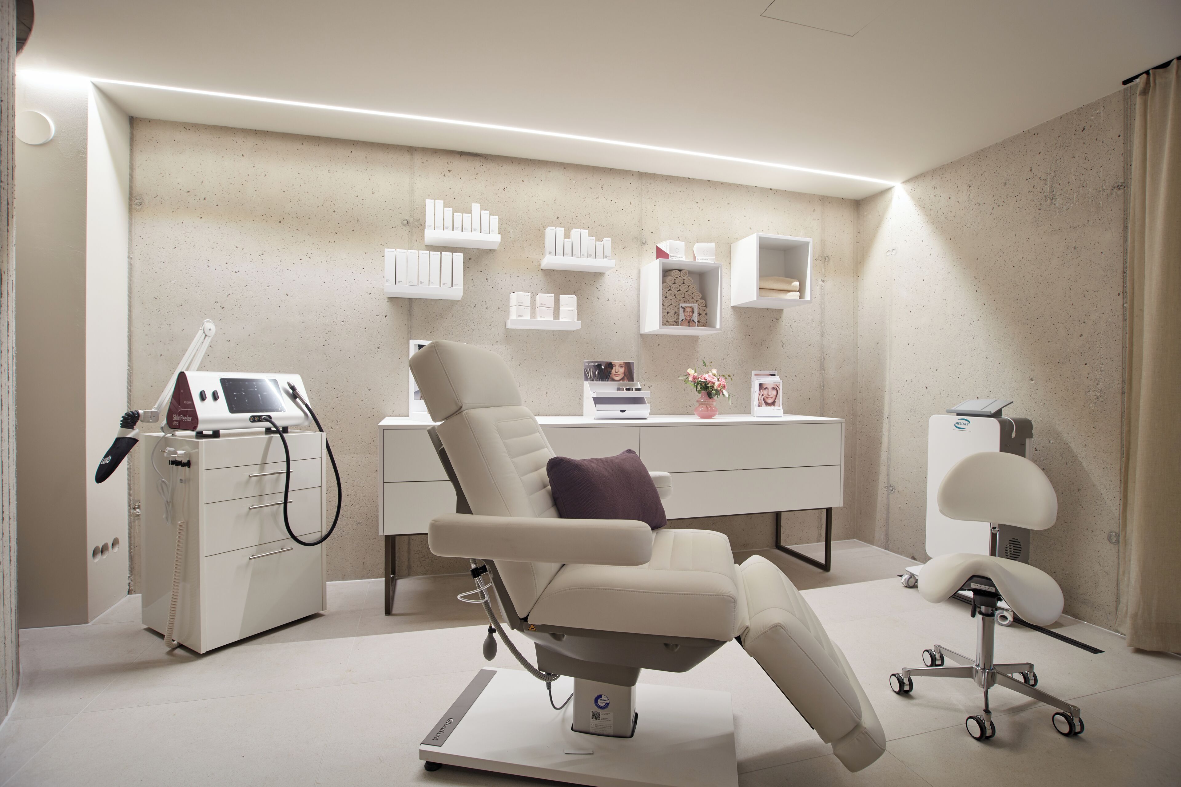 A medical examination room with a reclining chair, a desk with medical supplies, and a scale.