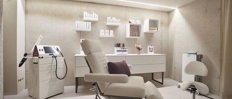 A medical examination room with a reclining chair, a desk with medical supplies, and a scale.