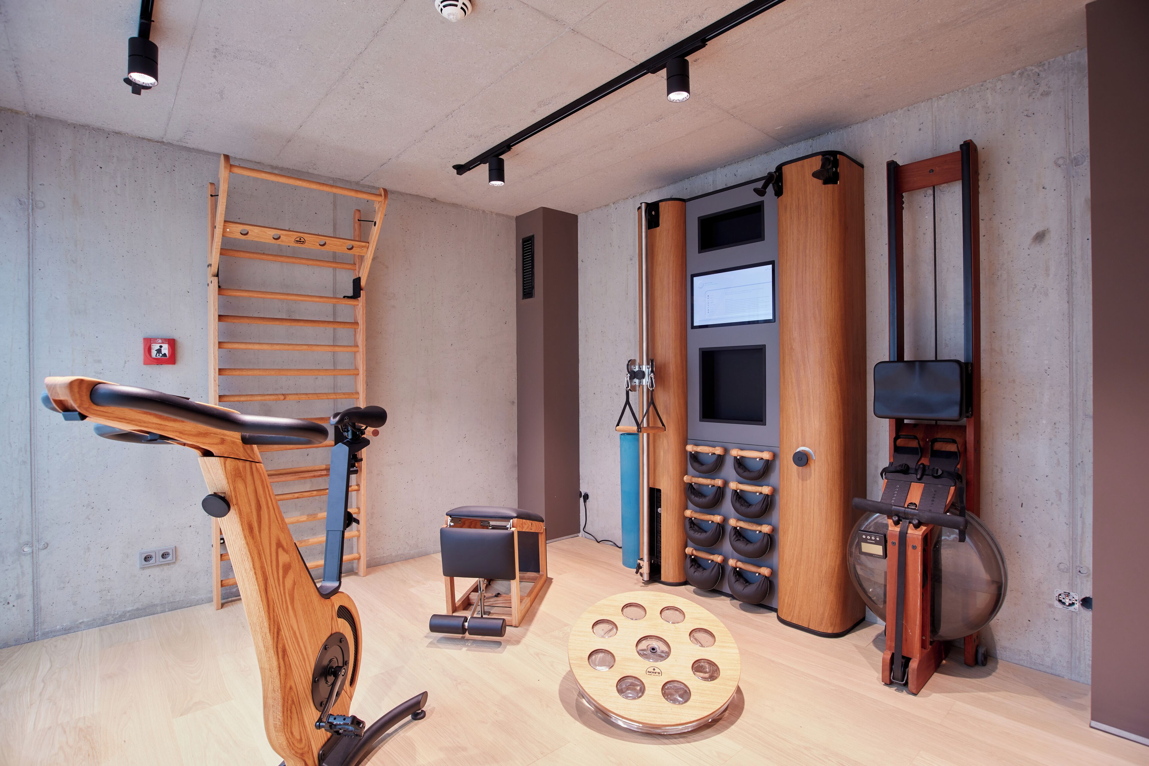 A gym with exercise equipment, a wooden ladder, and a large mirror.