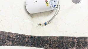 A bathroom with a toilet, a bidet, and a water heater. - Roomshala 005 Tom & Jerry (New Delhi)