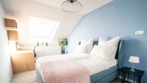 A bedroom with a bed, bedside table, and a window. - Noble Suite mit perfektem Wohn- und Arbeitskomfort (Gießen)