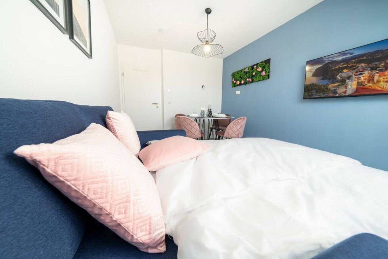 A bedroom with a bed, a desk, and a chair.