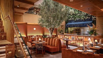 Un restaurant amb una zona central de seients, una barra i una escala.