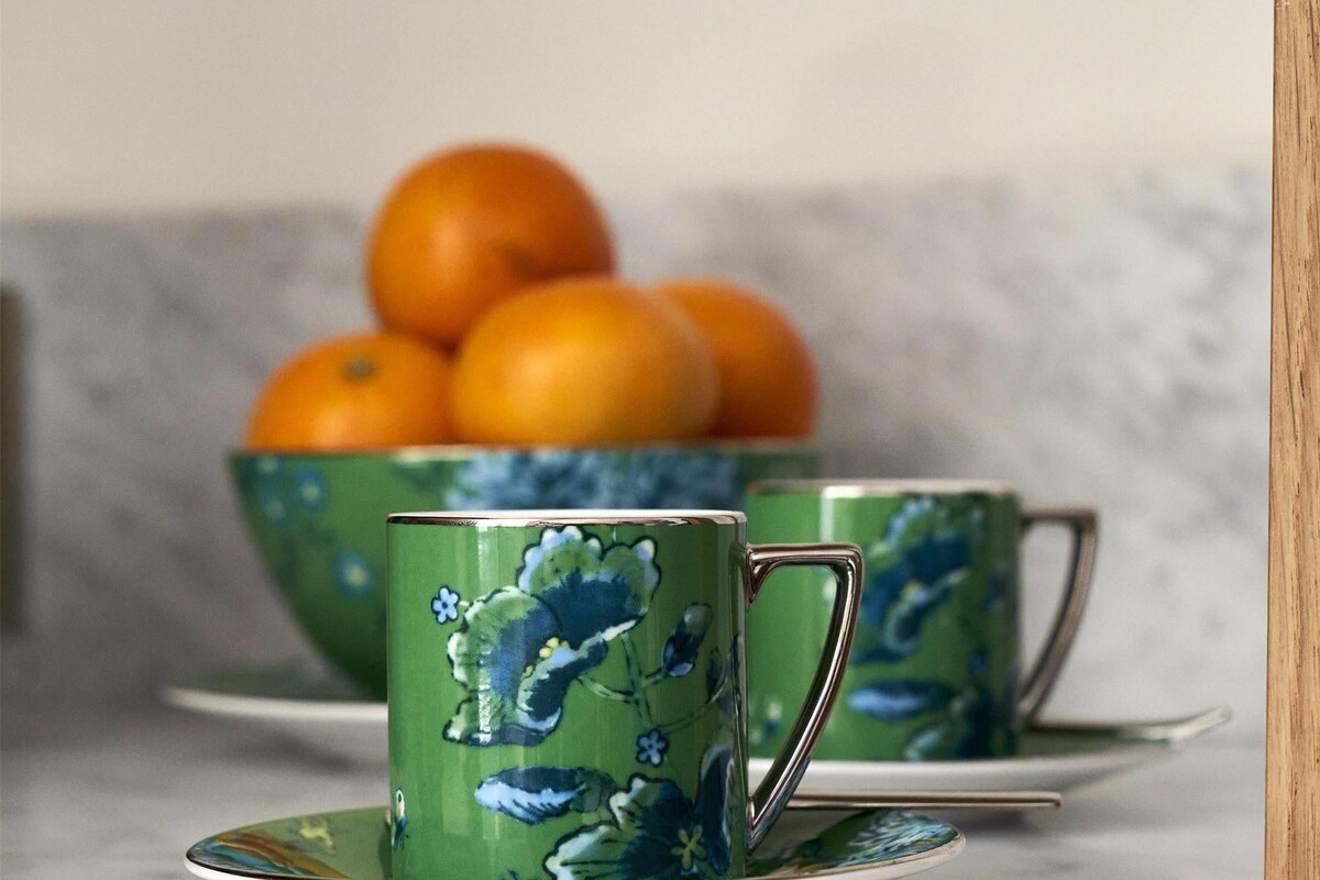 A kitchen counter with a marble surface, a wooden cabinet, and a bowl of oranges.