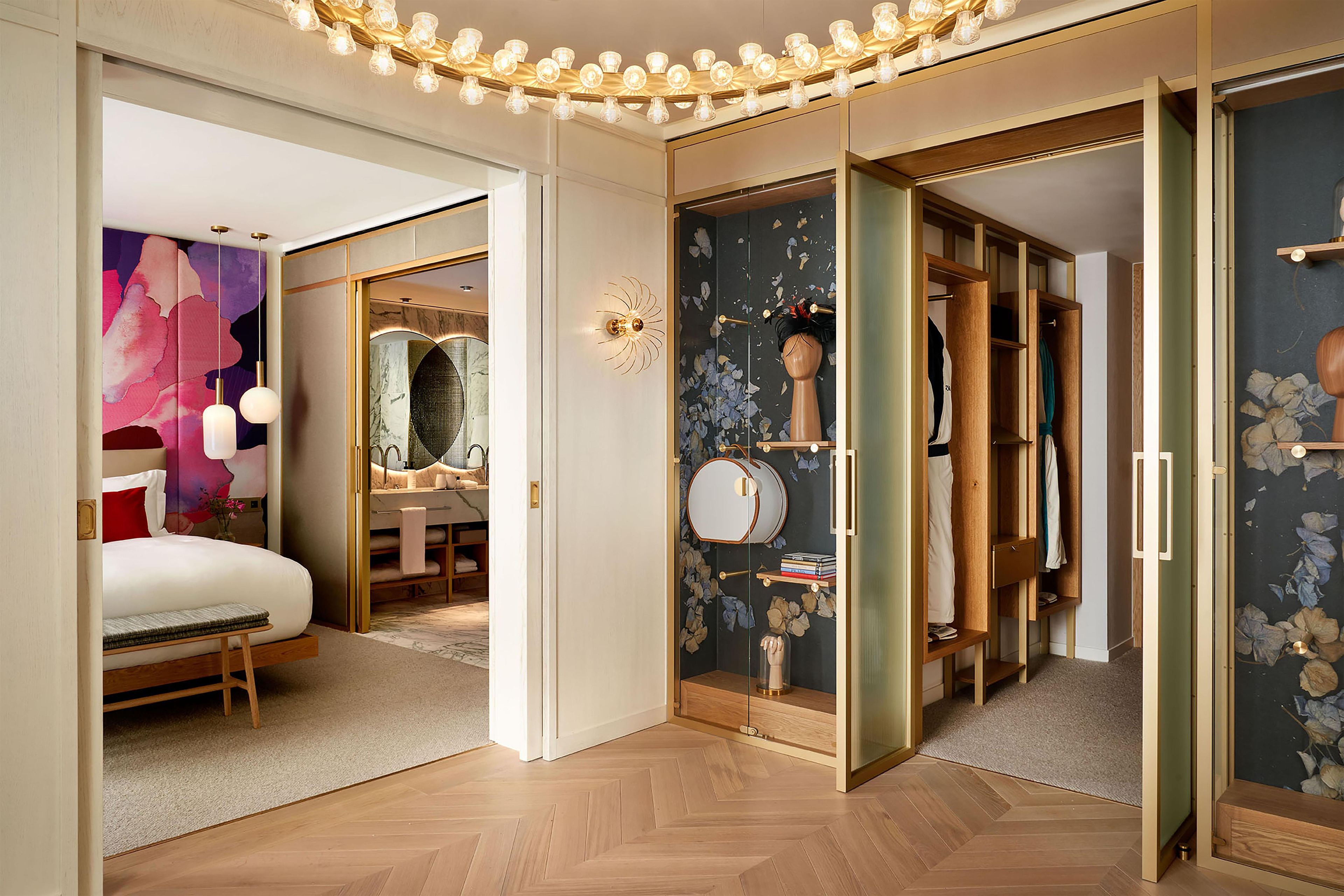 Een moderne slaapkamer met een bed, een kaptafel en een inloopkast met een spiegel en planken.