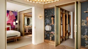 Een moderne slaapkamer met een bed, een kaptafel en een inloopkast met een spiegel en planken.