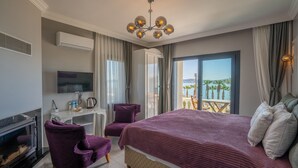 Una habitación de hotel con una cama grande, un escritorio, una silla, un televisor y una chimenea.
