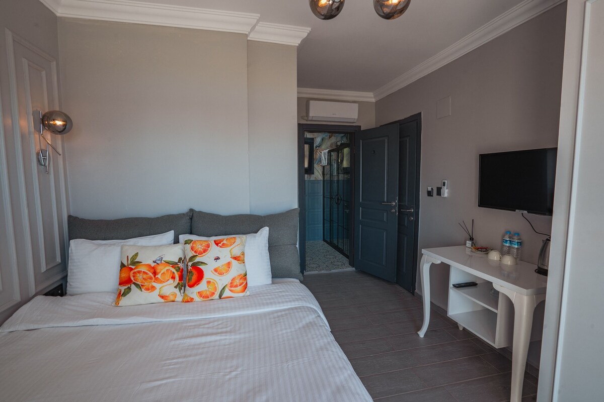 A hotel room with a bed, a desk, and a television.