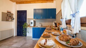 Een keuken met blauwe kastjes, een houten aanrechtblad en diverse etenswaren.