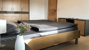 Una camera da letto moderna con un letto a telaio di legno, un comodino e una lampada da notte.