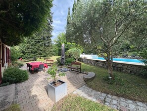 A patio area with a pool, outdoor seating, and a statue. - Villa with pool and garden - 30' from Lyon (Saint-Just-Chaleyssin)
