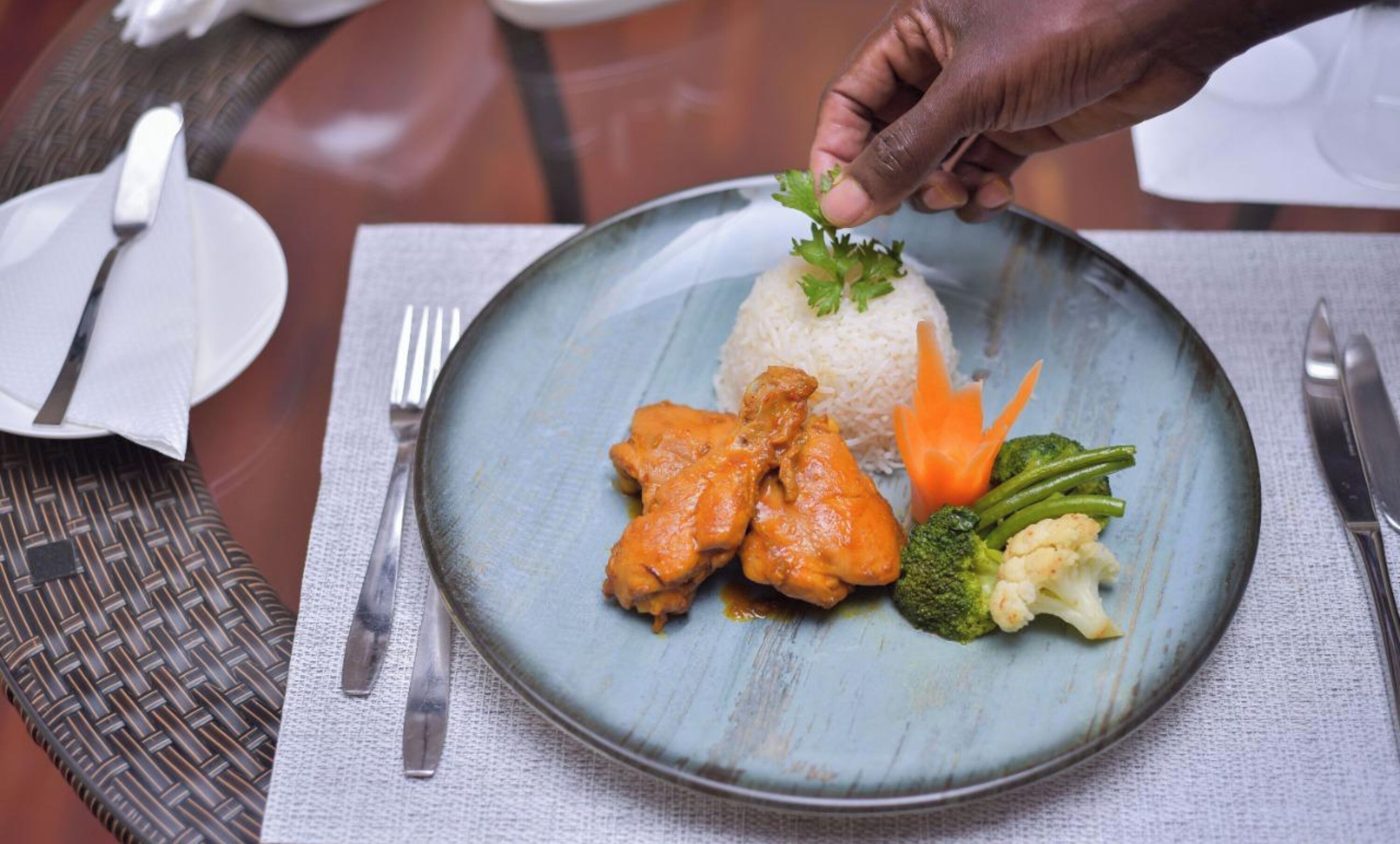 A plate with rice, chicken, carrots, broccoli, and cauliflower.