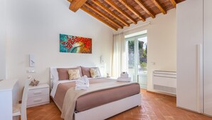 A bedroom with a bed, a desk, a chair, a wardrobe, and a window with curtains. - Chimera Tuscany Resort (Arezzo)