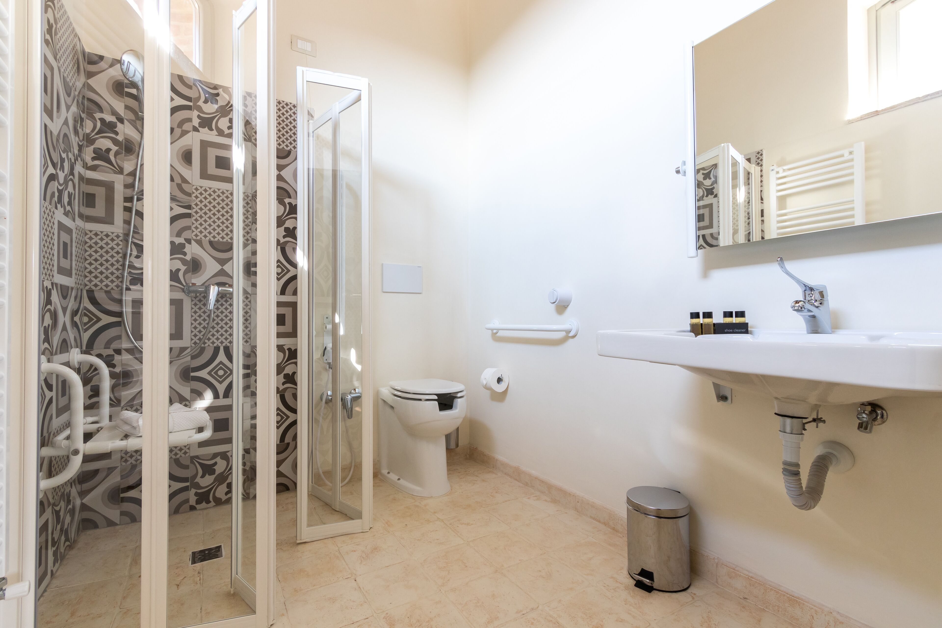 Ein Badezimmer mit Dusche, Toilette, Waschbecken und Mülleimer.