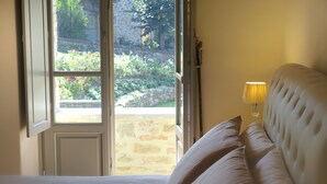 A bedroom with a bed, a window, and a lamp. - Chimera Tuscany Resort (Arezzo)