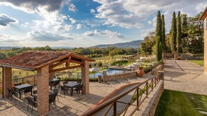 A patio area with outdoor seating, a pool, and a view of the countryside. - Chimera Tuscany Resort (Arezzo)