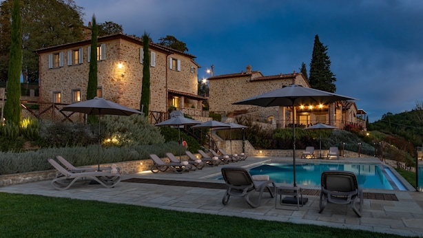 A stone villa with a swimming pool, outdoor seating, and a well-lit patio area. - Chimera Tuscany Resort (Arezzo)