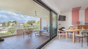 A balcony with a view of the town, a dining area with a table and chairs, and a sofa. - LE PARC Apartment for 5 By Sunset (Antibes)