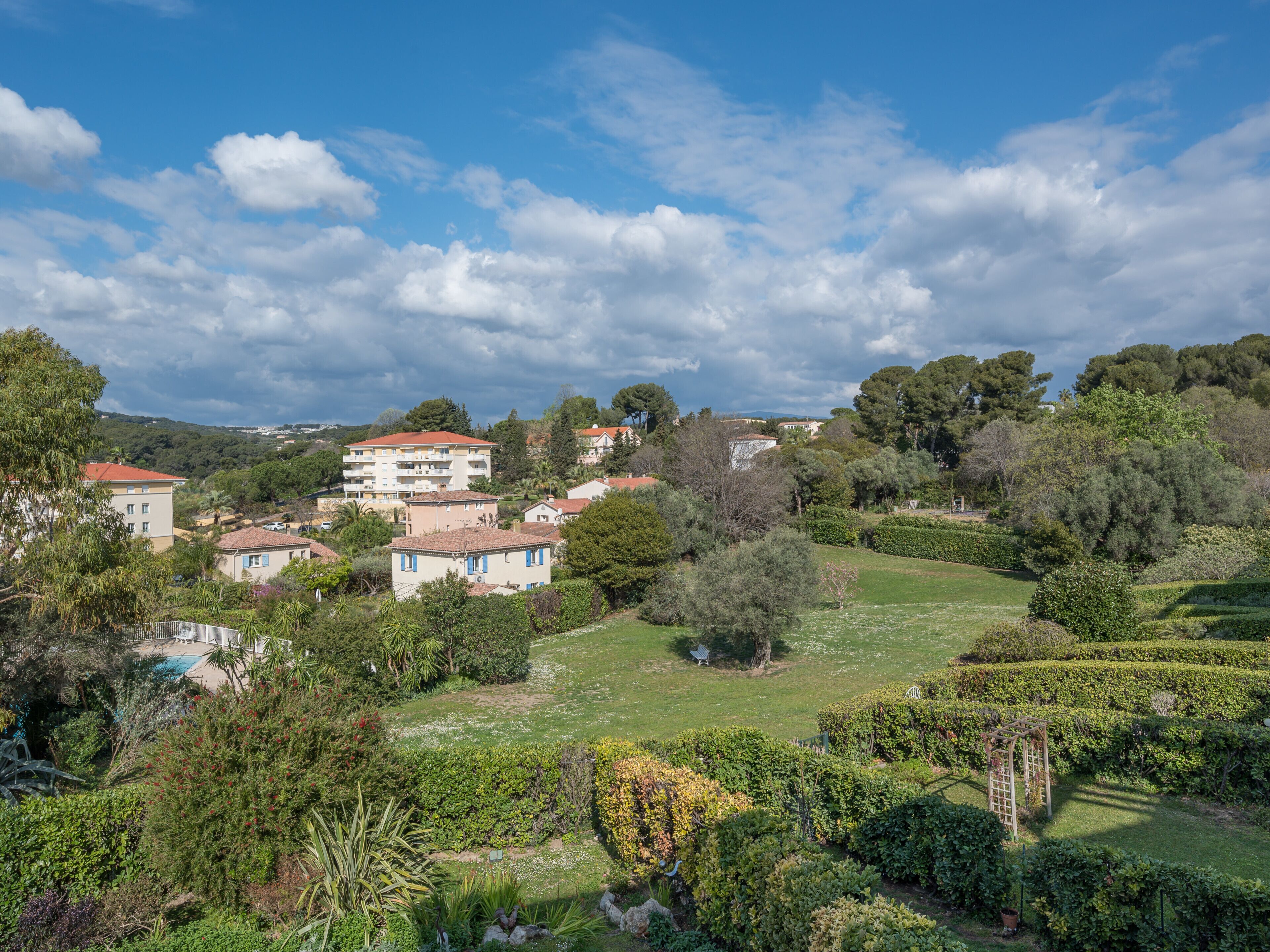 Área residencial com casas, jardim e piscina.