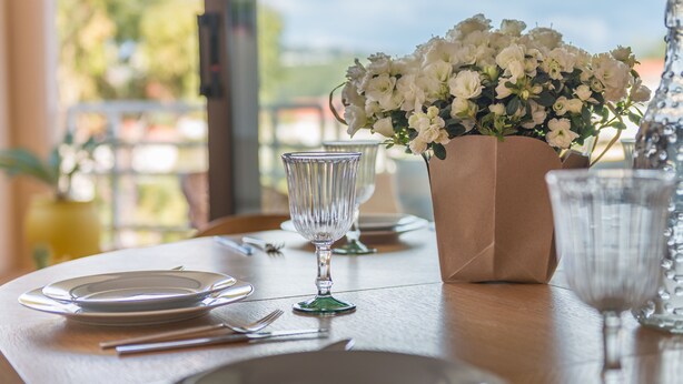 A table set for dining with plates, cutlery, and a vase of flowers. - LE PARC Apartment for 5 By Sunset (Antibes)