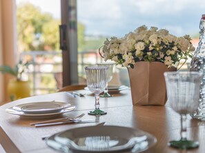 A table set for dining with plates, cutlery, and a vase of flowers.