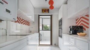 A modern kitchen with white cabinetry, a built-in oven, and a coffee machine. - LE PARC Apartment for 5 By Sunset (Antibes)
