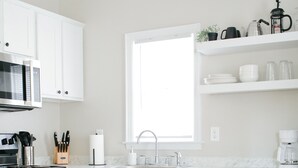 A modern kitchen with white cabinets, a stainless steel stove, and a window above the sink. - Come back to peace after busy days at Maxwell or downtown. (Montgomery)