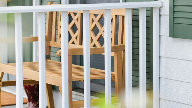 A wooden chair on a porch with white railings and green shutters. - Come back to peace after busy days at Maxwell or downtown. (Montgomery)