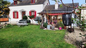 A white house with red shutters, a small garden, and a barbecue grill. - A 1h de Paris, et 1h des Châteaux de la Loire, (CHALETTE SUR LOING)