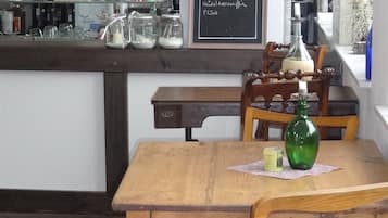 A kitchen with a wooden table and chairs, a chalkboard sign, and various kitchen items.