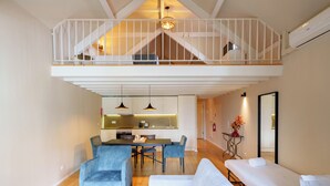 A modern interior with a dining area, sofas, a balcony, and a kitchen. - Porto Vitoria Apartments (Porto)