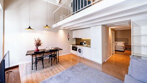 A modern apartment with a dining area, kitchen, and a loft bedroom. - Porto Vitoria Apartments (Porto)