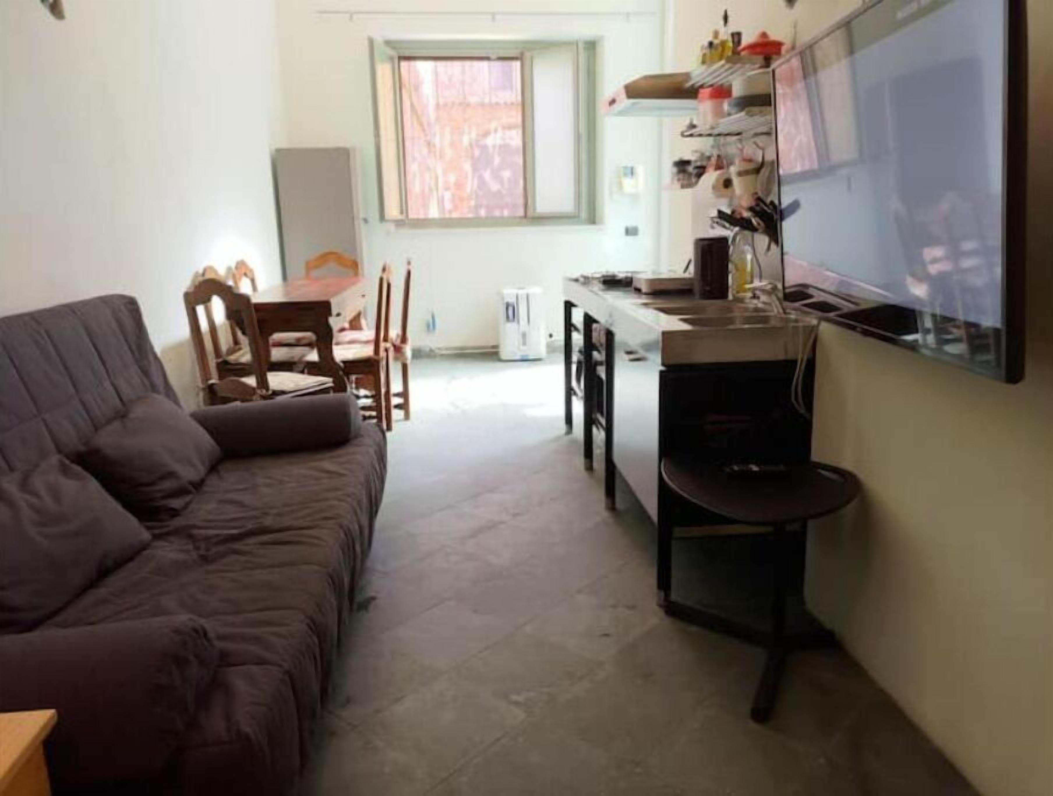 A compact living space with a sofa, a dining area, and a kitchenette.