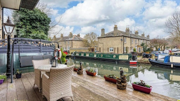 A riverside patio with wicker furniture, potted plants, and a canal view. - Hertford - Sleeps 2 - 92 Walking Score - Garden (Hertford)
