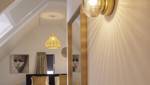 Un dormitorio con una cama grande, una araña y un espejo que refleja la habitación.