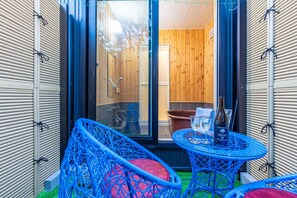 Relax in this serene space with a comfortable chair, a small table, and a potted plant.