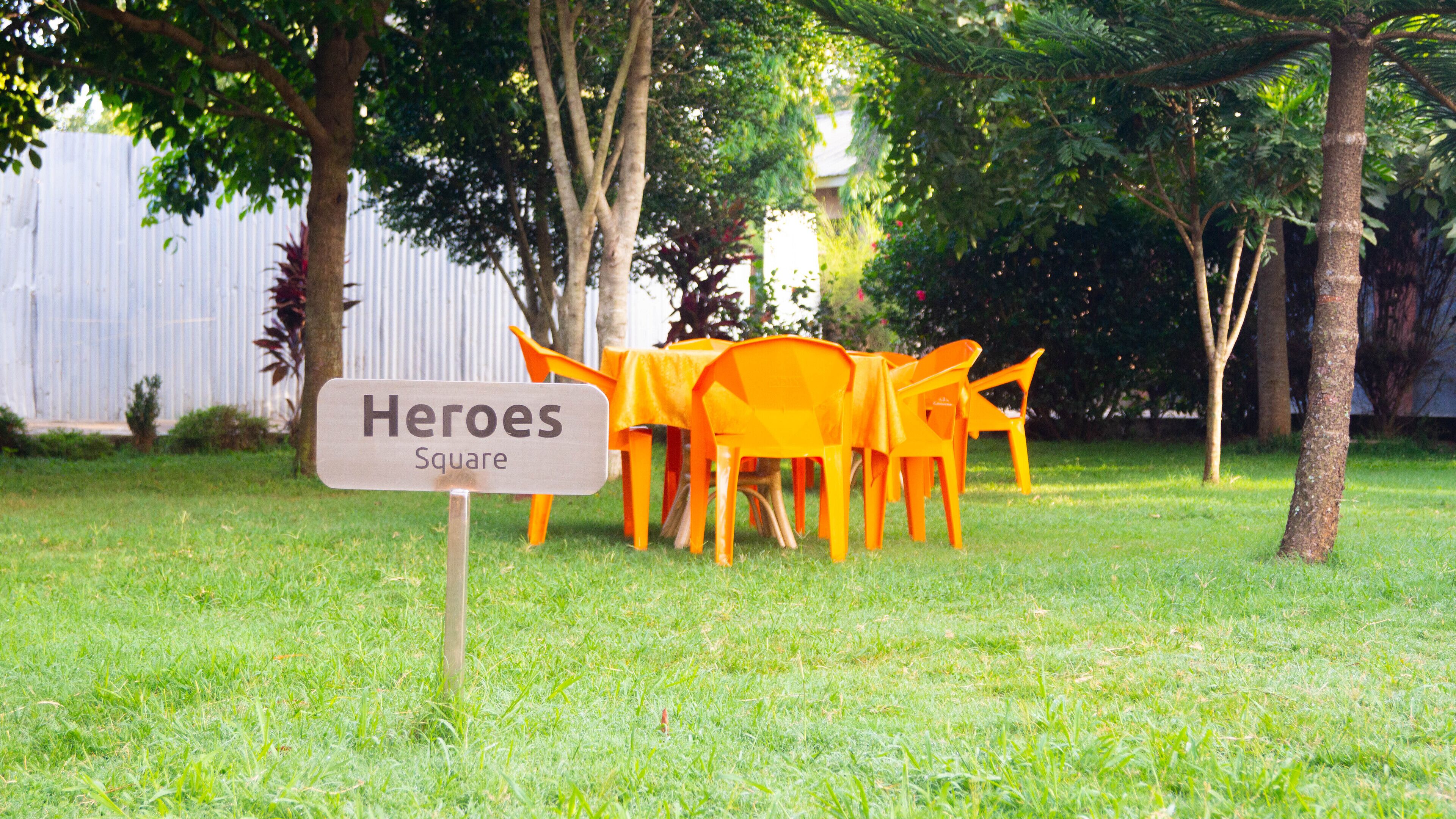 Et skilt med teksten 'Heroes Square', med orange stole placeret i forgrunden.