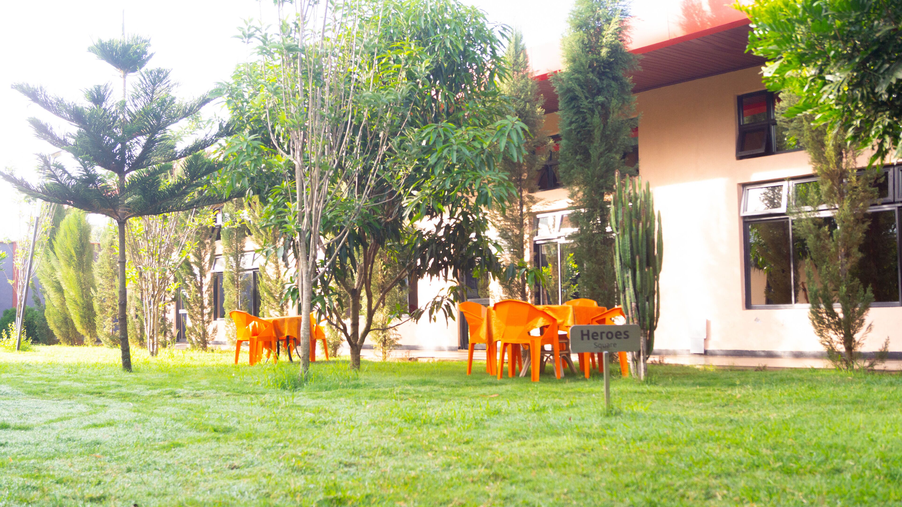 A grassy area with orange chairs and a sign reading "Heroes Square".