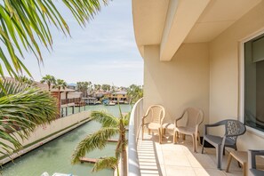 A balcony with chairs overlooking a marina and a canal.