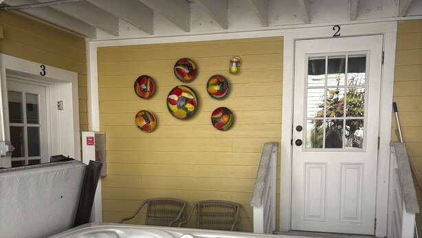 Een hottubgedeelte met een houten wand, een deur met de aanduiding '2', en verschillende wanddecoraties met fruitmotieven.