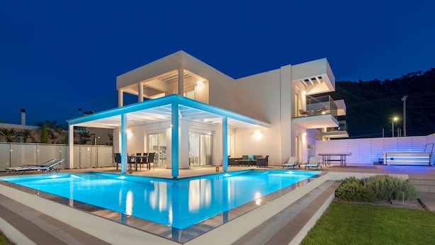 Une maison moderne à deux étages dotée d’une piscine, d’un espace extérieur aménagé et d’un patio couvert.