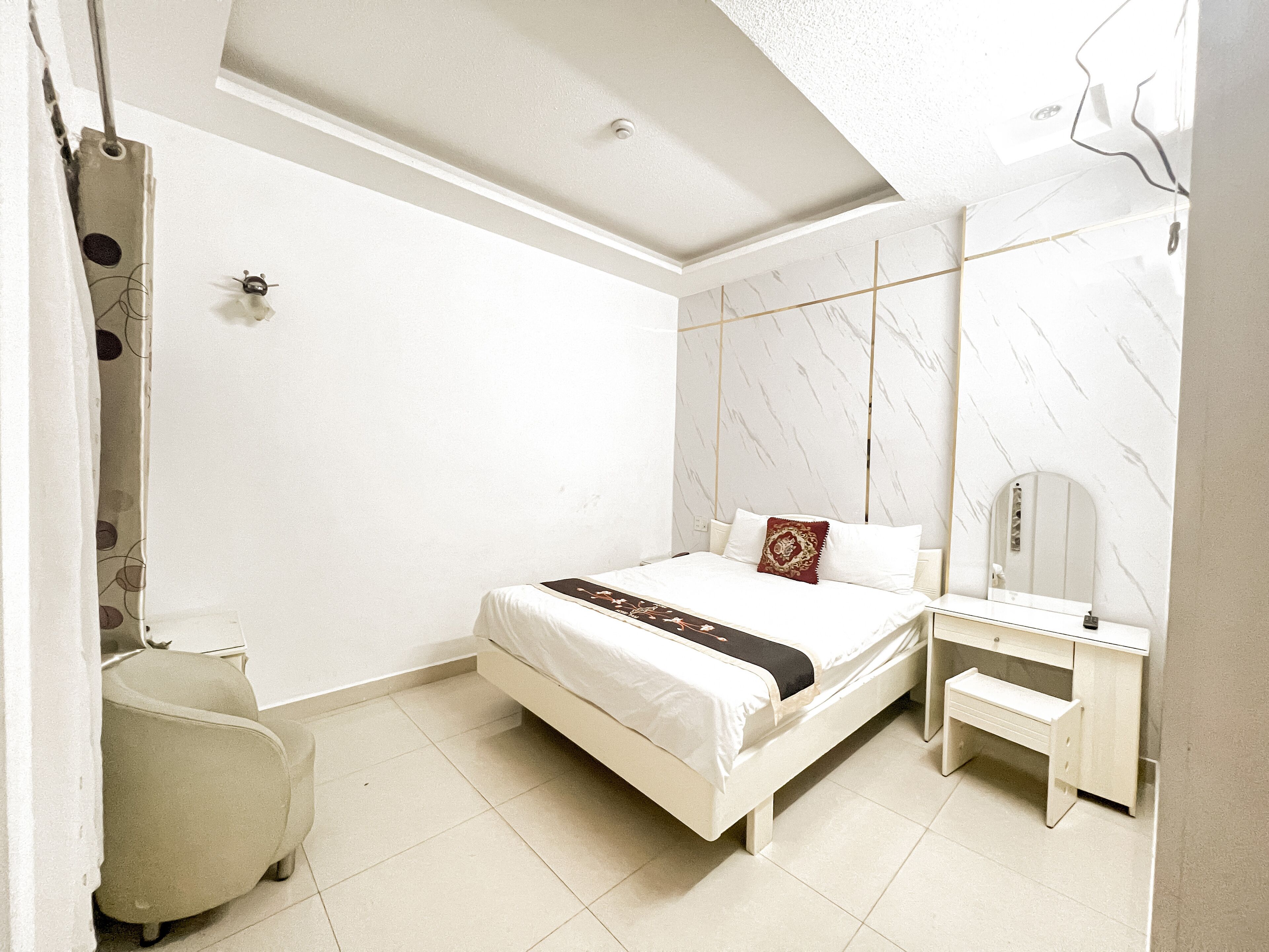 Una camera d'albergo moderna con un letto, un comodino e uno specchio.