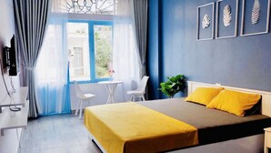 A hotel room with a bed, a desk, a chair, and a window with curtains. - La Casa Homestay Ha Long (Bai Chay)