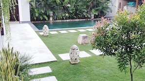 A well-maintained garden with a swimming pool, stone pathways, and lush greenery. - Gathering With 5 Bedroom Center House Villa (Legian)